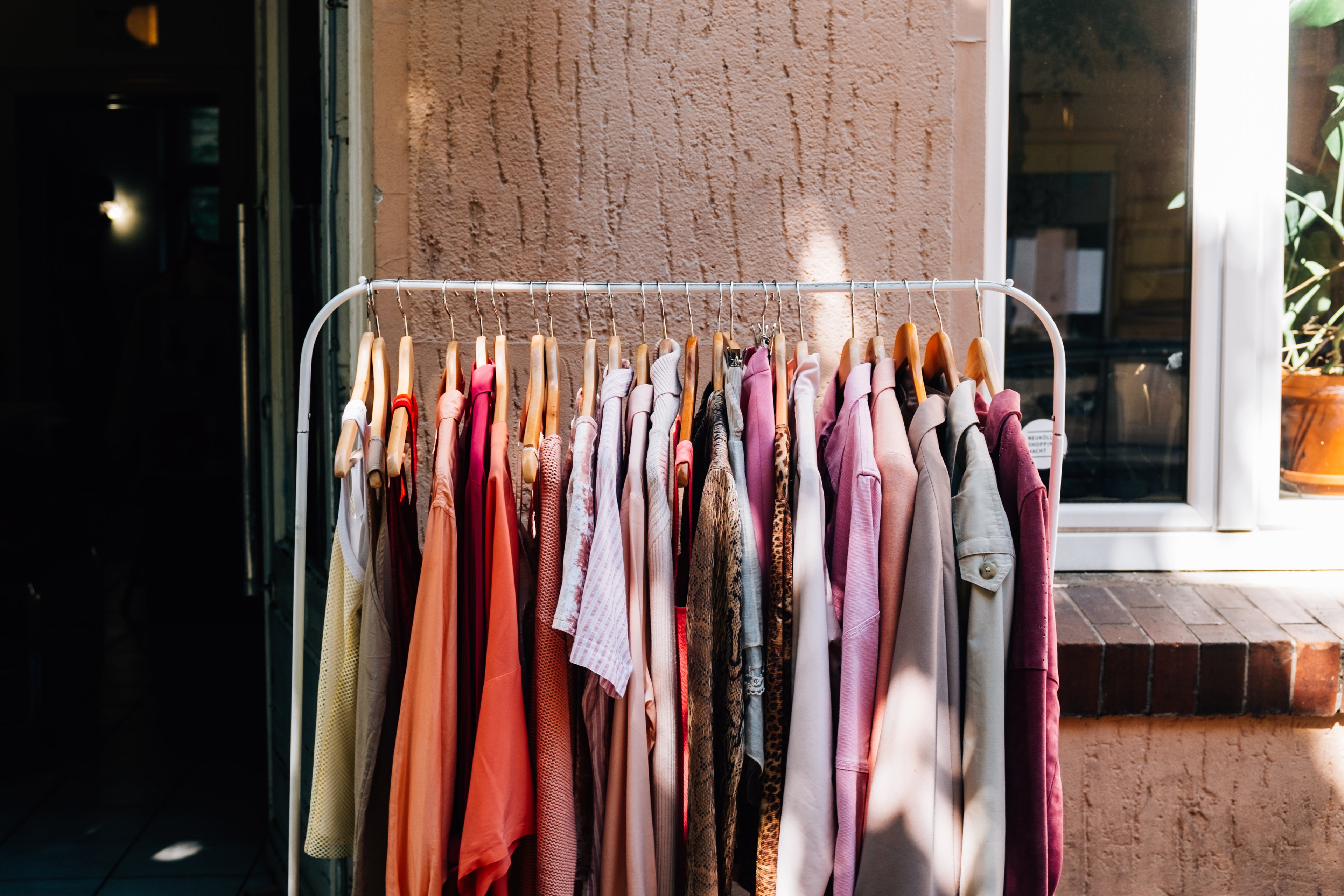 full-metal-clothing-rack-sits-outside-a-shops-entrance - OneCatBoutique